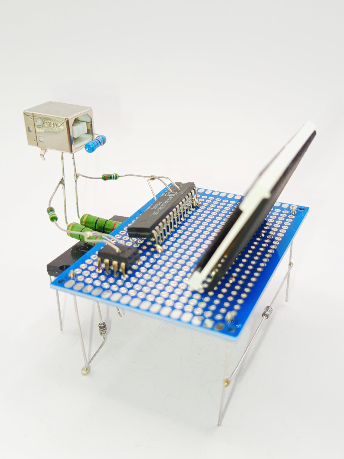 Figurine ou sculpture représentant un informaticien ou geek sur son ordinateur miniature fabriquée avec des composants électroniques recyclés