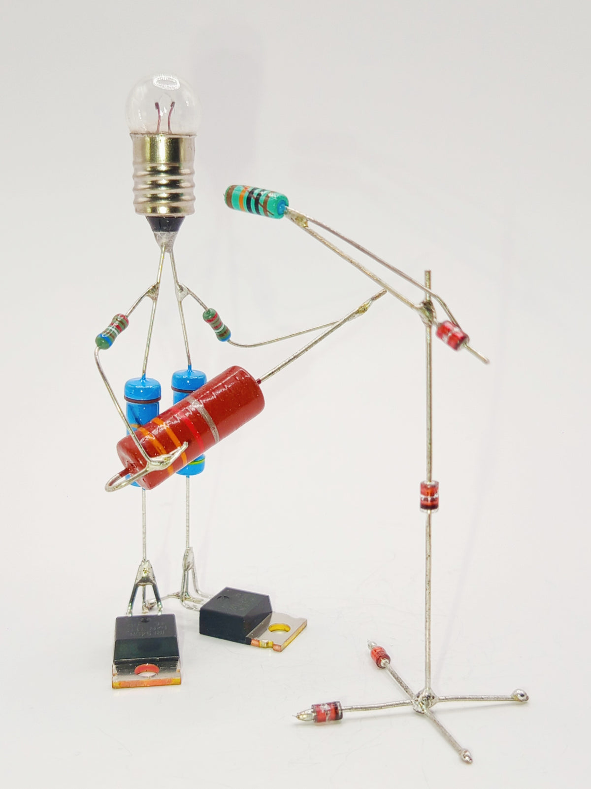 Figurine ou sculpture représentant un guitariste et son pied de micro miniature fabriquée avec des composants électroniques recyclés