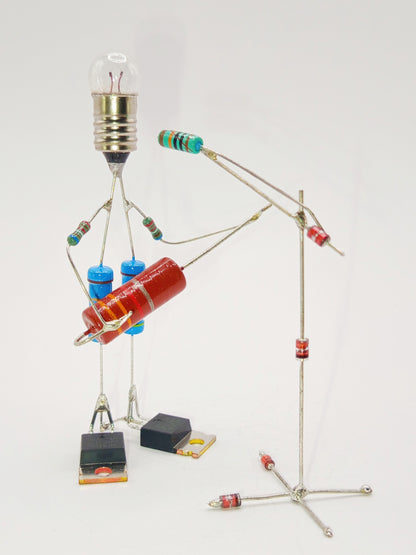 Figurine ou sculpture représentant un guitariste et son pied de micro miniature fabriquée avec des composants électroniques recyclés