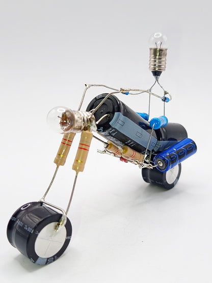 Une figurine en forme de moto de type chopper, fabriquée à partir de composants électroniques tels que des condensateurs, des résistances et des petites ampoules